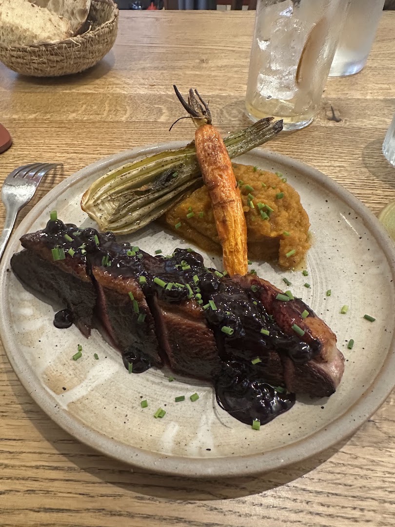 Une pièce de viande avec carottes rôties et sauce